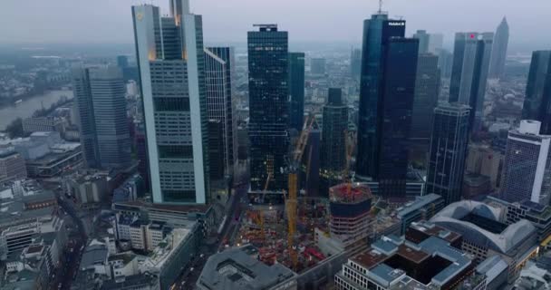 夕暮れ時にビジネスハブの近代的なダウンタウンの高層ビル群の空中上昇映像。フランクフルトはドイツのメインです — ストック動画