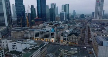 Alacakaranlıkta şehir merkezindeki çok katlı binaların görüntülerini indirin. Dükkanları olan sokaklar ve yaya bölgeleri. Arka planda modern gökdelenler. Frankfurt am Main, Almanya