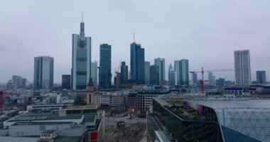 İleri, Rossmarkt etrafındaki binaların üzerinden uçuyor. Alacakaranlıkta bulutlu gökyüzüne karşı modern şehir merkezi gökdelenleri. Frankfurt am Main, Almanya