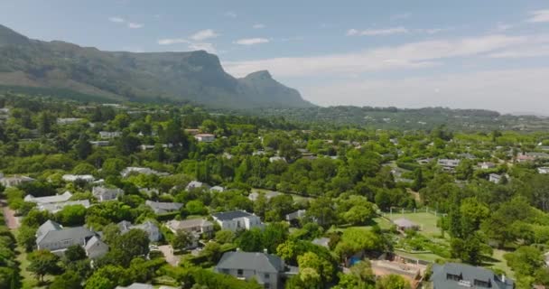 Вперед летят над жилым пригородом. Роскошные семейные дома расположены между пышными зелеными деревьями. Кейптаун, ЮАР — стоковое видео