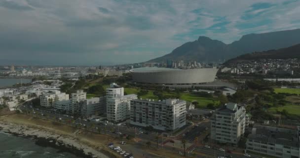 Imágenes aéreas ascendentes de la arena de fútbol moderno en la ciudad. Green Point Stadium cerca de la costa del mar. Montañas en el fondo. Ciudad del Cabo, Sudáfrica — Vídeos de Stock