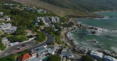 Deniz kıyısındaki varoşların üzerinden uç. Modern lüks konutlar ve tropikal seyahat yerlerindeki pansiyonlar. Cape Town, Güney Afrika