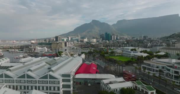 Rückwärts fliegen über Einkaufs- und Unterhaltungszentren. Gebäudekomplex in Victoria und Alfred Waterfront. Kapstadt, Südafrika — Stockvideo