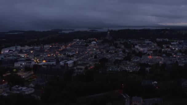 Images panoramiques aériennes de la ville du soir sous un ciel couvert. Lac et nuages enveloppaient les collines au loin. Killarney, Irlande — Video