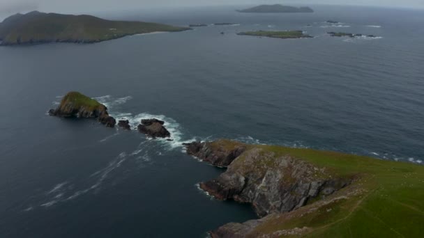 Letecké panoramatické záběry ostrovů na moři u pobřeží. Zelená tráva s skalnatými útesy na kopci Dunmore Head. Irsko — Stock video