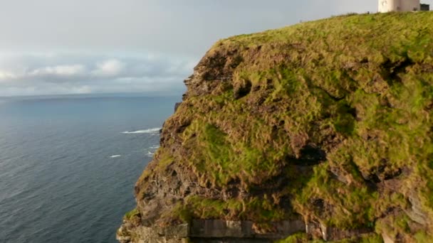 Vorwärts fliegen entlang der Meeresküste. Eine majestätische Steinmauer, die von der späten Nachmittagssonne erleuchtet wird. Cliffs of Moher, Irland — Stockvideo