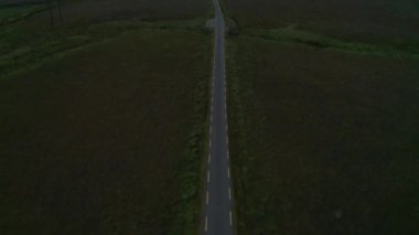 Kenarları sarı çizgili dar köy yolunun yüksek açılı görüntüsü. Manzarayı yukarı kaldır. İrlanda