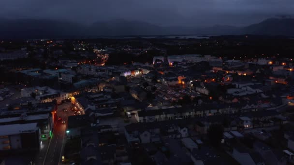 町の中心部の空中パノラマ映像。照らさ色の家のファサード。湖と背景の山。アイルランドのキラーニー — ストック動画