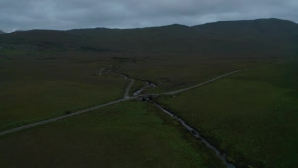 Geser dan panci rekaman udara jembatan batu tua di atas sungai di pedesaan. Jalan pedalaman antar padang rumput. Irlandia — Stok Video
