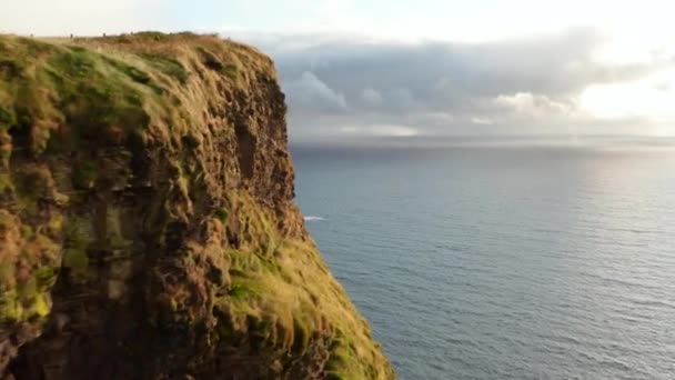 Vorwärts fliegen um die Felswand. Schöne Landschaft mit hohen vertikalen Klippen an der Meeresküste. Cliffs of Moher, Irland — Stockvideo