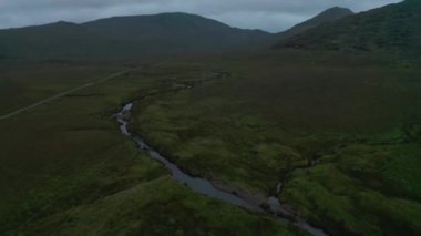 Güç hatlarının üzerinden uçarak çayırlarda akıntıya doğru ilerliyorlar. Uzak konum manzarası. İrlanda