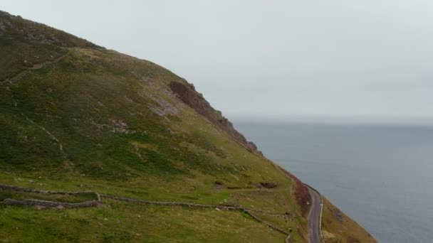 Vue aérienne du magnifique paysage côtier. Révélation glissante de la route panoramique menant haut au-dessus de l'eau. Irlande — Video