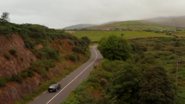 차를 타고 시골길을 질주하는 것을 추적하고 있습니다. 구름 이 끼고 날씨가 불안정합니다. 아일랜드 — 비디오