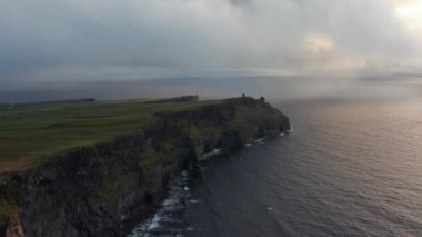 Yüksek uçurumlu deniz kıyısının hava panoramik görüntüleri. Dalgalar kıyıya vuruyor. İrlanda 'nın Moher Kayalıkları