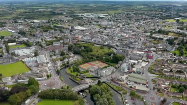 Luchtfoto 's van de stad. Gebouwen en straten vanaf hoogte. Sportcentrum met speelvelden aan de waterkant. Ennis, Ierland — Stockvideo
