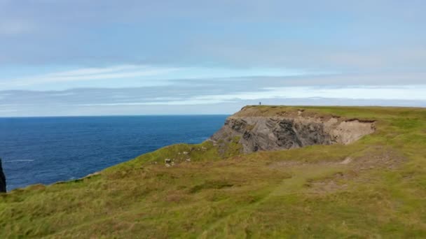 Eteenpäin lentää yli rannikon. Korkeat kalliot putoavat jyrkästi mereen. Paljastavat aallot törmäävät rannikolle. Kilkee Cliff Walk, Irlanti — kuvapankkivideo