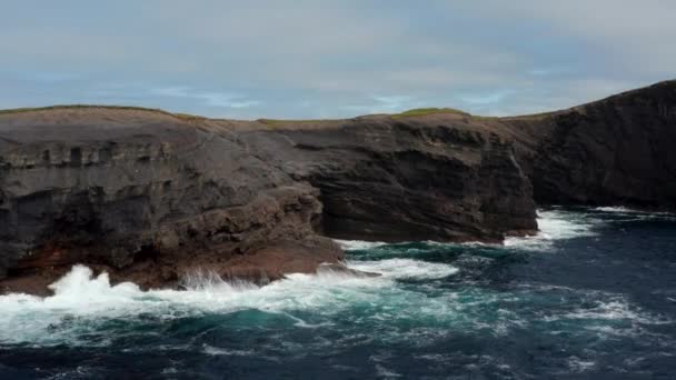 Steigende Filmaufnahmen von Wellen, die auf die Küste krachen und weißen Schaum bilden. Planschen an felsigen Klippen. Kilkee Cliff Walk, Irland — Stockvideo