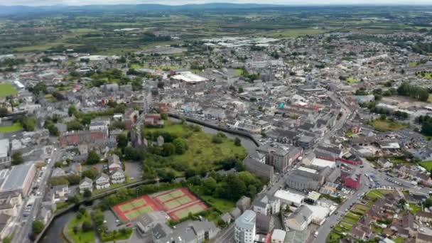 İleri, şehrin yukarısına uçar. Nehir kıyısındaki spor merkezi ve tarihi kasaba ilçesi. Havadan panoramik çekim. Ennis, İrlanda — Stok video