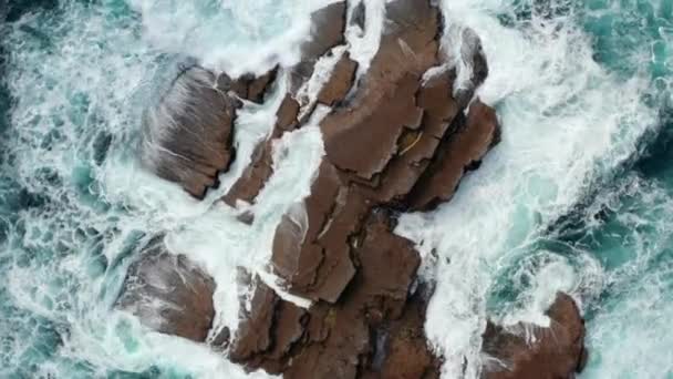 Pájaros aéreos ojos arriba hacia abajo descendente y giratorio vista de las olas chocando y rodando sobre rocas costeras. Paisajes naturales abstractos. Kilkee Cliff Walk, Irlanda — Vídeos de Stock