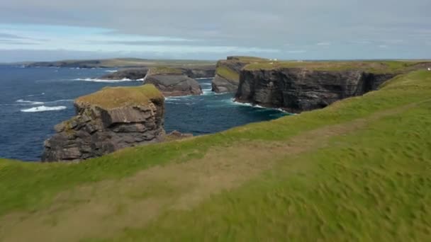 Backwards fly above rugged sea coast with high and steep cliffs. Breath taking nature scenery. Kilkee Cliff Walk, Ireland — Stock Video