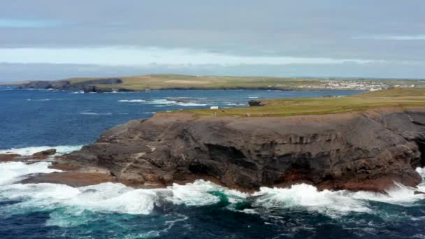 Slide och panorera bilder sten udde på havskusten. Havet kraschar mot stranden. Kilkee Cliff Walk, Irland — Stockvideo