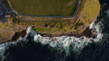 Havadan kuşların gözü tepede kıyı kayalıklarına çarpan dalgaları görüyor. İnanılmaz doğal bir manzara. İrlanda 'nın Moher Kayalıkları