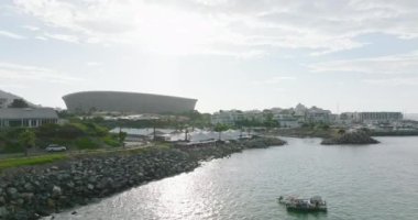 Modern Green Point futbol stadyumunun kayma ve pan çekimi, deniz kıyısında restoranla uçmak. Cape Town, Güney Afrika