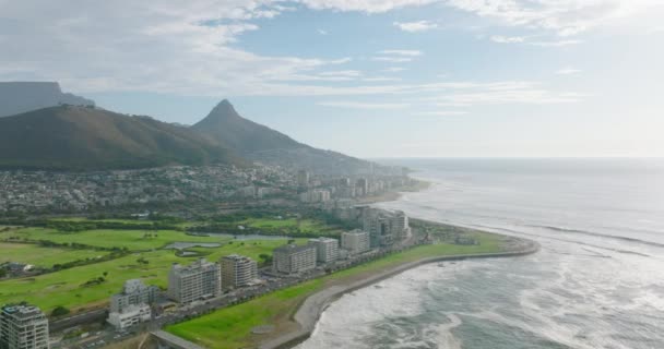 Filmato panoramico aereo della costa del mare. Multipiano hotel o condomini e prato verde brillante intorno. Città del Capo, Sud Africa — Video Stock