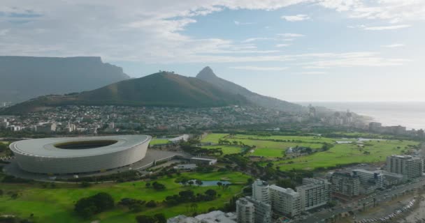 Slider do local do esporte na cidade com cume de montanha no fundo. Campo de golfe e arena de futebol moderno. Cidade do Cabo, África do Sul — Vídeo de Stock