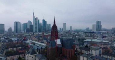 Frankfurter Dom kulesinin çevresindeki binaların üzerinden uçuyor. Arka planda iş merkezindeki modern ofis kuleleri. Frankfurt am Main, Almanya