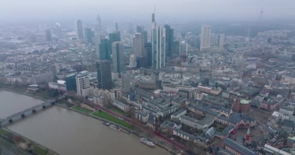 Aerial panoramic footage of city with high rise buildings in business hub. Hazy view of large town. Wide river calmly flowing. Frankfurt am Main, Germany — Stock Video