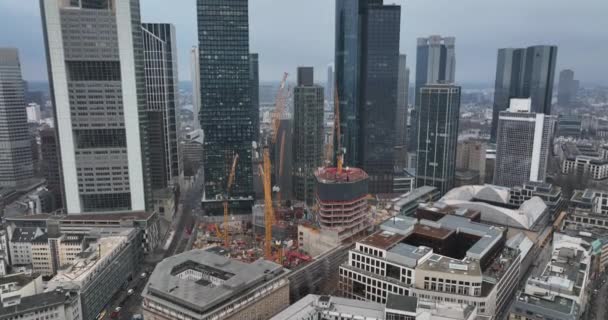 Modern tall skyscrapers in business district. Tilt down focus on construction site with machinery. Frankfurt am Main, Germany — Stock Video