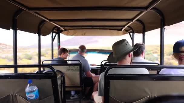 Rückansicht des Innenraums des Safari-Geländewagens. Besucher sitzen auf Sitzen und beobachten die Landschaft. Safaripark, Südafrika — Stockvideo