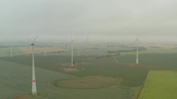 Voorwaarts vliegen boven het veld in vlakke landschap. Wazig zicht op draaiende rotoren van windturbines. Vermindering van groene energie, ecologie en koolstofvoetafdruk — Stockvideo