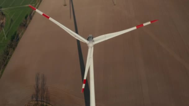 Vol descendant autour de l'éolienne. Spinning rotor coulée ombre sur le terrain. Énergie verte, écologie et concept de réduction de l'empreinte carbone — Video