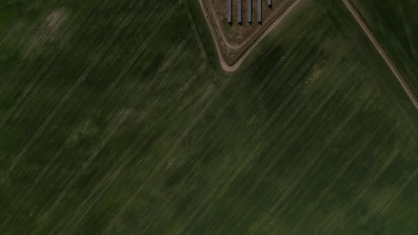 Зверху вниз панорамні кадри зеленого сільськогосподарського поля. Виявлення рядів сонячних батарей на фотоелектричній електростанції. Концепція зеленої енергетики, екології та зменшення відбитків вуглецю — стокове відео