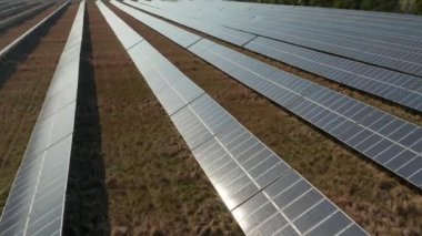 Yeşil alanda güneş enerjisi santralinin üzerinde ilerliyorlar. Kasabadaki binalar arka planda. Yeşil enerji, ekoloji ve karbon ayak izi azaltma kavramı