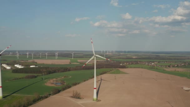 Çizgili uçlu dönen pervane. Düz kırsaldaki rüzgar türbinlerinin hava görüntüsü. Yeşil enerji, ekoloji ve karbon ayak izi azaltma kavramı — Stok video