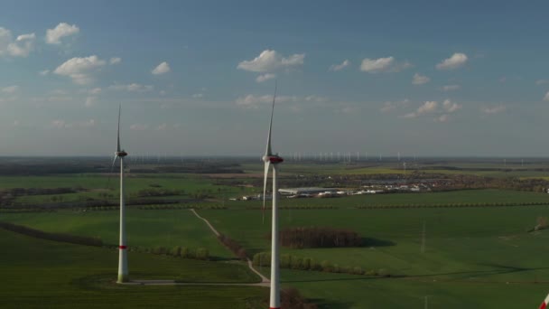 Groep draaiende rotoren van windkrachtcentrales in de avondzon. Platte landbouwgrond. Vermindering van groene energie, ecologie en koolstofvoetafdruk — Stockvideo