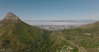 Yoğun yolun dağ geçidinden büyük şehre inen hava görüntüleri. Lions Head Dağı çevresindeki manzaranın üzerinde yükseliyor. Cape Town, Güney Afrika