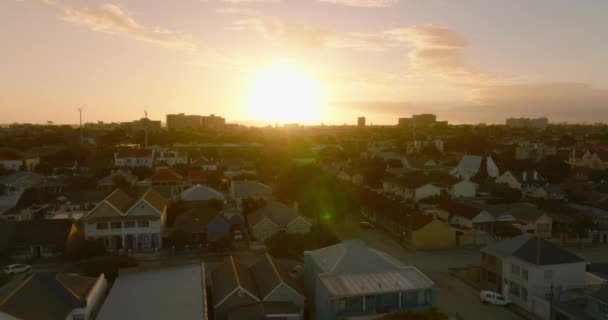 Avante sobrevoe o desenvolvimento residencial na vizinhança urbana. Vista contra o colorido céu do pôr do sol. Port Elisabeth, África do Sul — Vídeo de Stock