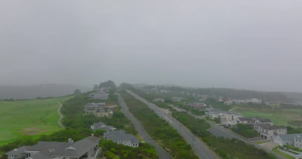 Framåt flyger över gatan och familjehus runt. Dimmigt väder som begränsar sikten. Port Elisabeth, Sydafrika — Stockvideo