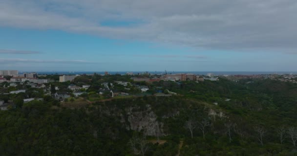 Letecký pohled na luxusní rezidence nad strmým srázem. Městská čtvrť obklopena zelenou vegetací a mořem v pozadí. Port Elisabeth, Jihoafrická republika