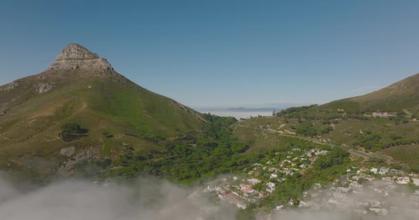 Légi felvétel a ködből emelkedő hegyekről. Oroszlánok fej hegy és a környező út halad. Fokváros, Dél-Afrika — Stock videók