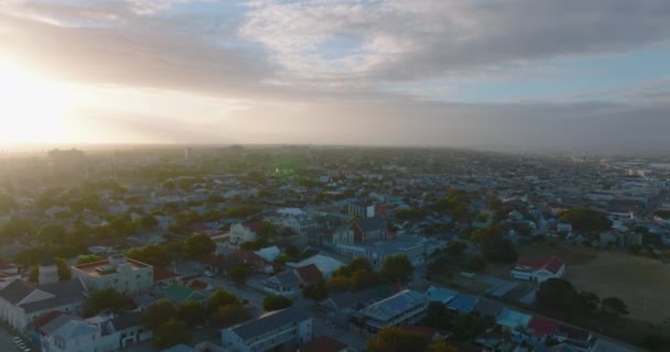 Vorwärts fliegen über Häuser in Wohnvierteln. Stadt gegen untergehende Sonne. Port Elisabeth, Südafrika — Stockvideo