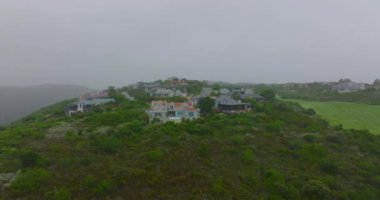 Tepedeki lüks konutların havadan görünüşü. Şehrin eteklerindeki puslu havanın kayma ve yan görüntüsü. Port Elisabeth, Güney Afrika