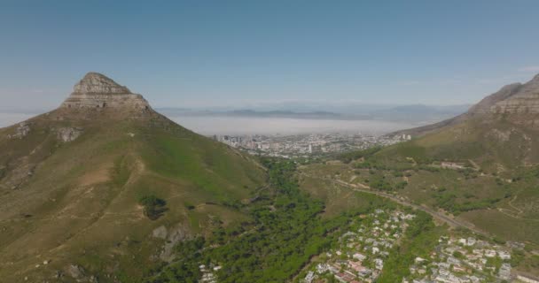 前方の風景の上に飛ぶ。街の上にそびえる岩の頂上とライオンズの頭の山。南アフリカ共和国ケープタウン — ストック動画