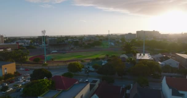 Slide e pan tiro de área de esportes na cidade. Estádio atlético vazio contra o pôr-do-sol. Port Elisabeth, África do Sul — Vídeo de Stock