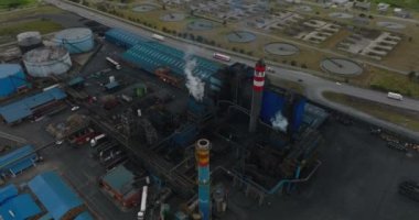 Buhar ya da duman yayarak sanayi fabrikasında uçmak. Etrafta dolaşan araçlar var. Port Elisabeth, Güney Afrika