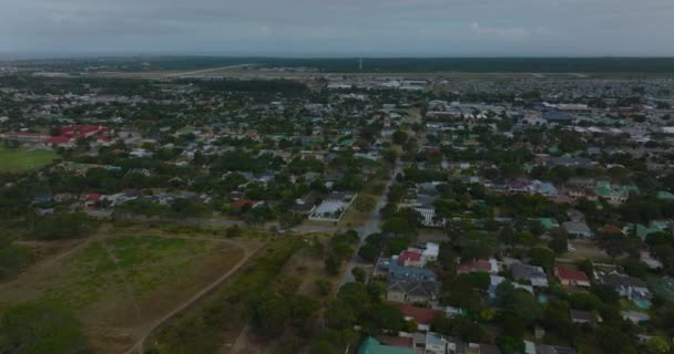 Vlieg boven familiehuizen in stedelijk stadsdeel aan de rand van de stad. Luchtfoto panoramisch uitzicht op residentiële satelliet. Port Elisabeth, Zuid-Afrika — Stockvideo